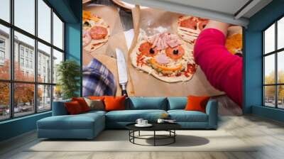 Master class for children on baking funny halloween pizza. Young children learn to cook a funny monster pizza. Kids preparing homemade piizza. Little cook. Wall mural