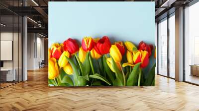 Red Yellow tulips flowers on blue background. Waiting for spring, seasonal holiday. Happy Easter card, 8 march Woman International Day. Flat lay, top view, copy space, banner, flyer Wall mural