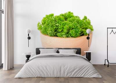 Side view composition with fresh green curley parsley leaves in the wooden bowl isolated on white background. One variety of Europe’s most popular herbs. 
 Wall mural