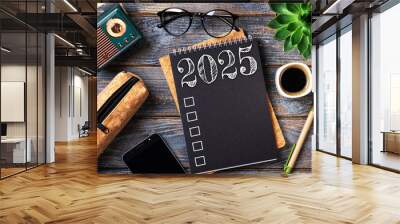 New year resolutions 2025 on desk. 2025 goals list with notebook, coffee cup, plant on wooden table. Resolutions, plan, goals, action, checklist, idea concept. New Year 2025 resolutions. Copy space Wall mural