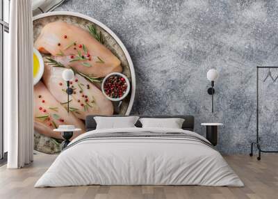 Raw uncooked chicken breasts with spices and herbs on gray concrete table, chicken meat with ingredients for cooking. Top view, copy space Wall mural