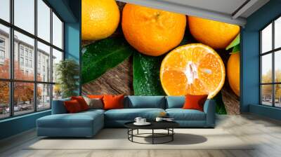 Tangerine, mandarines, clementine, orange fruits with green leaves on wooden table. Fresh tangerines citrus fruits background. Long web format Wall mural