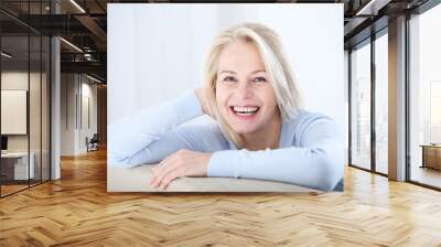 Active beautiful middle-aged woman smiling friendly and looking in camera. Woman's face closeup. Realistic images without retouching with their own imperfections. Selective focus. Wall mural