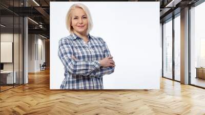 Attractive middle aged woman  in a plaid shirt with folded arms isolated on white background Wall mural