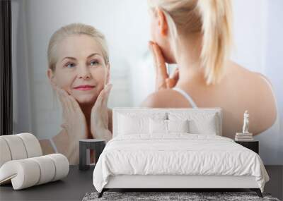 Middle aged woman looking at wrinkles in mirror. Plastic surgery and collagen injections. Makeup. Macro face. Selective focus Wall mural