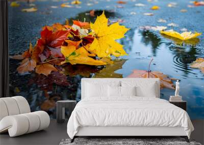 A cluster of autumn leaves in a puddle reflecting the cloudy sky, selective focus to emphasize the leaves against a soft reflection Wall mural