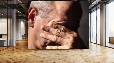 elderly man with face closed by hand Wall mural