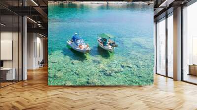 Two boats on crystal clear waters, serene and picturesque scene. Wall mural