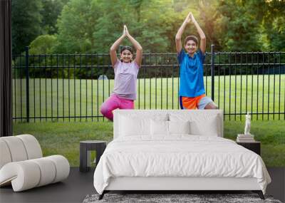 Siblings Practicing Yoga Outdoors in the Morning Wall mural