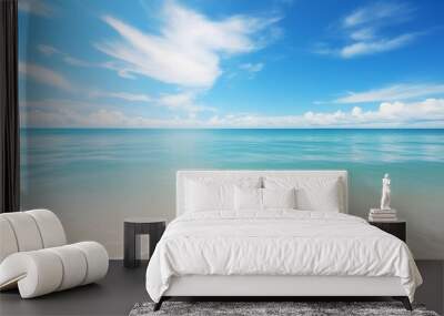 A tranquil beach with clear water, white sand, and a serene sky Wall mural