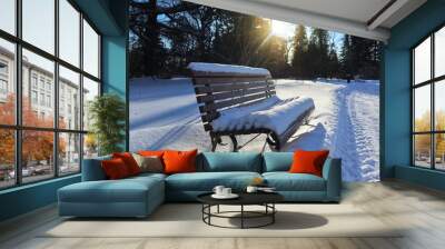 Snowy winter landscape with a snow-covered bench. Beautiful view on a winter day with a frozen plants in snow, illuminated by natural sunlight.  Wall mural