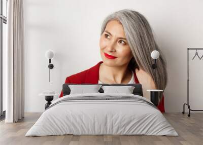 Beauty and haircare concept. Close up of elegant asian senior woman showing shiny and healthy grey hair, smiling and looking aside, white background Wall mural