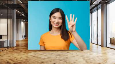 Close-up charismatic tender stylish asian female show number four fingers, smiling happily, making order, explain how much items want buy, stand blue background carefree Wall mural