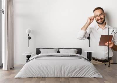 Confident business man working on digital tablet, smiling happy, standing over white background Wall mural