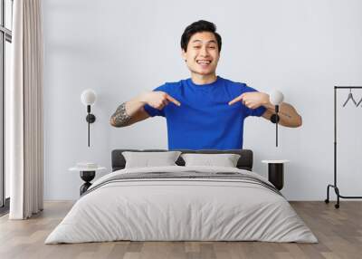 Different emotions, people lifestyle and advertising concept. Carefree smiling handsome asian man pointing at himself and smiling proud. Guy show-off, guarantee own personal help, grey background Wall mural