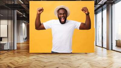 Handsome young Afro-American man employee feeling excited, gesturing actively, keeping fists clenched, exclaiming joyfully with mouth wide opened, happy with good luck or promotion at work Wall mural