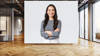 Lifestyle, beauty and fashion, people emotions concept. Young asian female office manager, CEO with pleased expression standing over white background, smiling with arms crossed over chest Wall mural