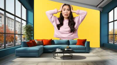 Lifestyle, emotions and advertisement concept. Anxious asian woman in panic look at disaster. grab head and looking frustrated and alarmed, feeling nervous, standing yellow background Wall mural