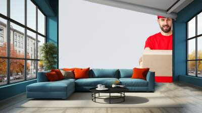 Order delivery, online shopping and package shipping concept. Cheeky handsome bearded courier in red uniform, handing box package to client. Employee wink to you and give order parcel Wall mural