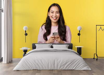 People emotions, lifestyle leisure and beauty concept. Happy and surprised pretty korean girl in stylish outfit, looking amazed with broad smile camera after reading great news in mobile appplication Wall mural