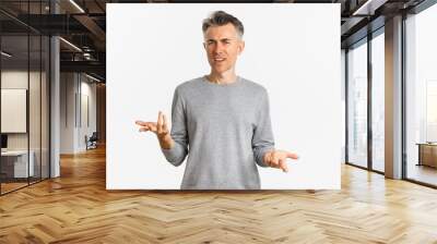 Portrait of confused and disappointed middle-aged man arguing, cant understand something and asking why, standing over white background perplexed Wall mural