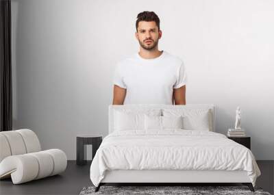 Portrait of smiling young man in a white t-shirt isolated on white background. Wall mural