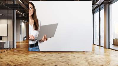 Portrait of young office woman, entrepreneur answer clients on laptop, working with computer with happy face, standing over white background Wall mural