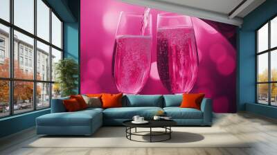 Two glasses of pink champagne are poured into each other. Concept of celebration and romance Wall mural