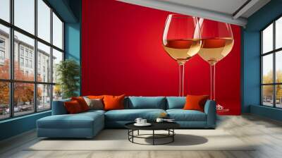 white wine in glasses isolated on a red background Wall mural