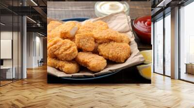 chicken nuggets with red and white sauce on a brown wooden background. fast food close-up Wall mural