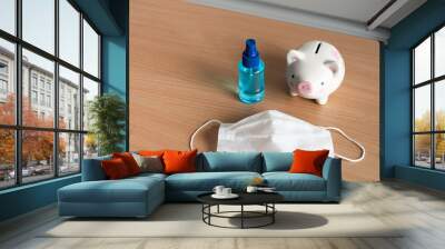 piggybank with alcohol protect prey and surgical mask on wood backgrounds,Payment and cost of protect ourself from coronavirus or covid-19 virus world pandemic effect to world economic concept. Wall mural