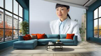 smiling Japanese business woman working at laptop Wall mural