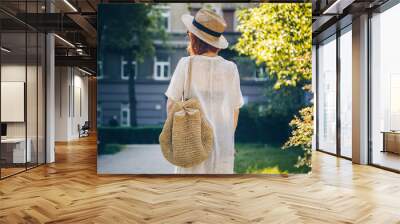 Back shot of a fashionable tourist woman exploring the city Wall mural