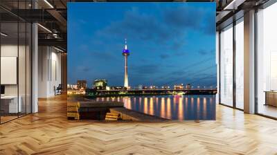 Skyline of Dusseldorf, the capital of the German federal state of North Rhine-Westphalia, in a beautiful sunset with the Rhine on the left and the Pegeluhr and St. Lambertus Basilika on the right.  Wall mural