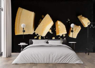 Sliced ​​parmesan cheese on black background. Wall mural