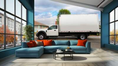 An unbraded commercial grade and heavy duty moving truck or furniture delivery vehicle parked infront of a residential home. Wall mural