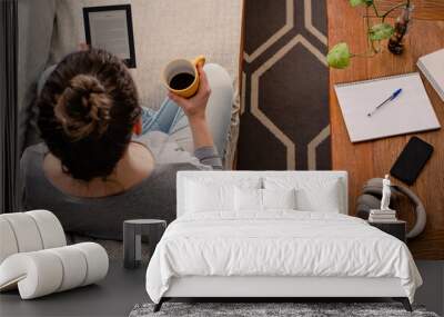 Woman reading e-book while drinking coffee Wall mural