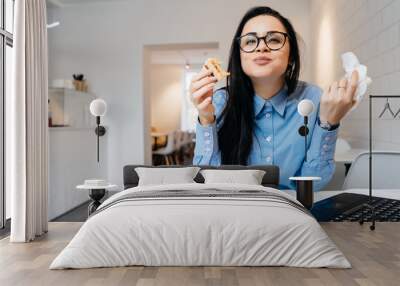 hungry woman eats at the office at a sandwich table Wall mural