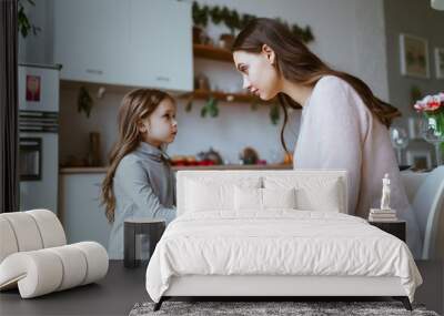 mom with a little daughter in the kitchen. the girl tells something and mom listens carefully to her Wall mural