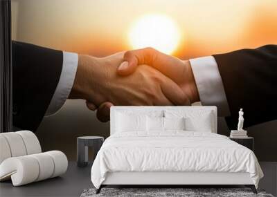 Two hands shaking against a sunset backdrop, symbolizing partnership and agreement. Wall mural