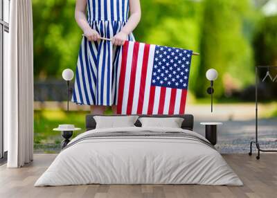 Adorable little girl holding american flag outdoors on beautiful summer day Wall mural