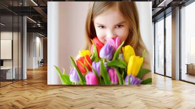 Adorable smiling little girl with tulips Wall mural