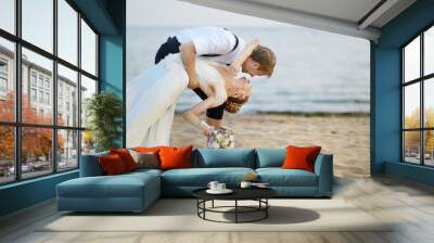 Beach wedding: bride and groom by the sea Wall mural