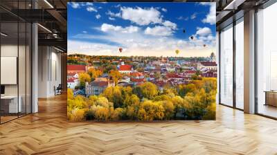 Beautiful autumn panorama of Vilnius old town with colorful hot air balloons in the sky Wall mural