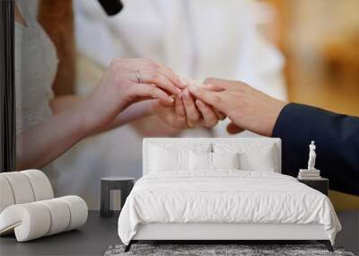 bride putting the ring on groom's finger Wall mural