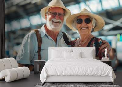 Cheerful senior couple ready to go travelling together. Retired man and woman waiting to board a plane at an airport. Summer vacation and holidays older people. Wall mural