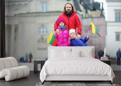 Father and daughters with a flag on Lithuanian independence day holding tricolor Lithuanian flag Wall mural