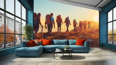 Group of tourists walking atop of a mountain on sunny sunset. Wall mural