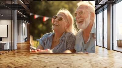 Happy cheerful couple having great time at at BBQ party. Elderly man and woman celebrating 4th of July outdoors with their friends and family. Wall mural