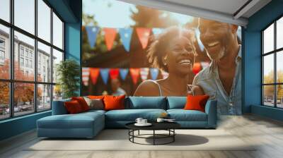 Happy cheerful couple having great time at at BBQ party. Young man and woman celebrating 4th of July outdoors with their friends and family. Wall mural